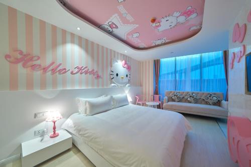 a bedroom with a hello kitty room with a bed and a couch at Aizhu Boutique Theme Hotel in Xiamen