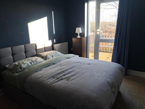 a bedroom with a bed and a window with a door at Delightful double room in home in Nottingham