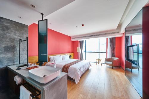 a hotel room with a bed and a sink at Aizhu Boutique Theme Hotel in Xiamen