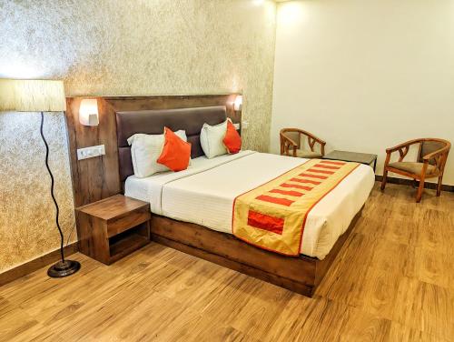 a bedroom with a large bed with orange pillows at Elegance Suites Hotel, Gomti Nagar in Lucknow