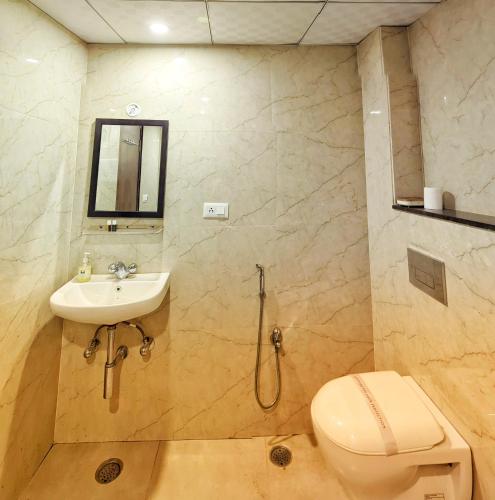 a bathroom with a toilet and a sink at Elegance Suites Hotel, Gomti Nagar in Lucknow