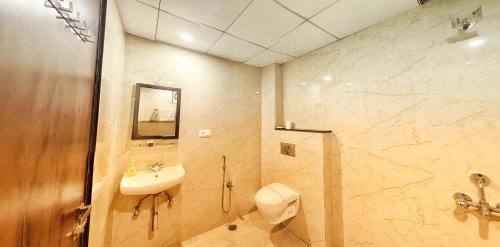 a bathroom with a sink and a toilet and a shower at Elegance Suites Hotel, Gomti Nagar in Lucknow