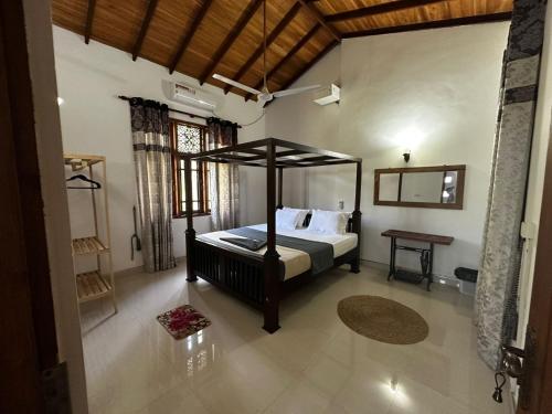 a bedroom with a canopy bed in a room at Curve Hiri in Dickwella