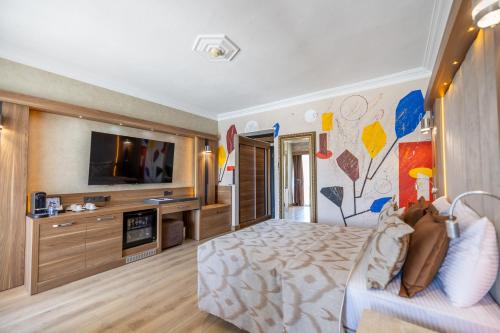 a hotel room with a bed and a tv at LAUR HOTELS Experience & Elegance in Didim