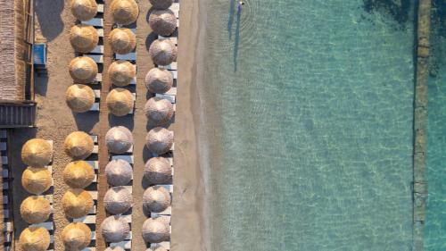 an overhead view of a swimming pool with straw hats at LAUR HOTELS Experience & Elegance in Didim