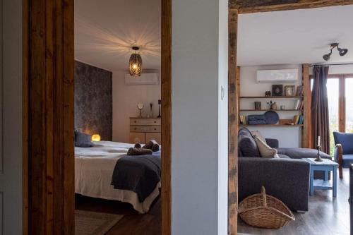 a bedroom with a bed and a couch and a mirror at Csillagfény Házikó in Nagymaros