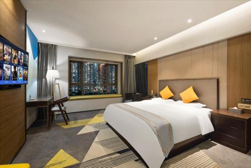 a bedroom with a bed and a desk and a television at 如家派柏云酒店 成都新会展大源地铁站店 in Chengdu