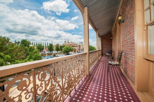 a balcony with chairs and a view of a city at Cobb & Co Court Boutique Hotel in Mudgee