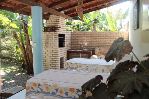 a patio with a table and a brick wall at Residencial Aracuã in Bombinhas