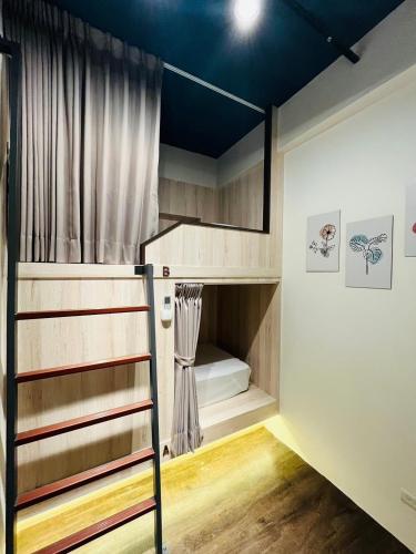 a room with a bunk bed with a ladder at Jincheng Hostel in Changhua City