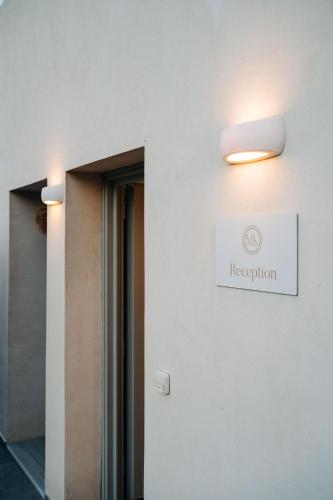 a sign on the side of a building with a reception sign at Makrikythera Luxury Suites - Private Pool or Hot Tub Suites in Dhiakofti