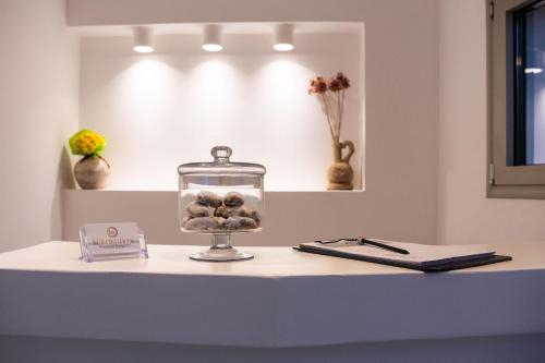 a table with a glass jar with balls in it at Makrikythera Luxury Suites - Private Pool or Hot Tub Suites in Dhiakofti