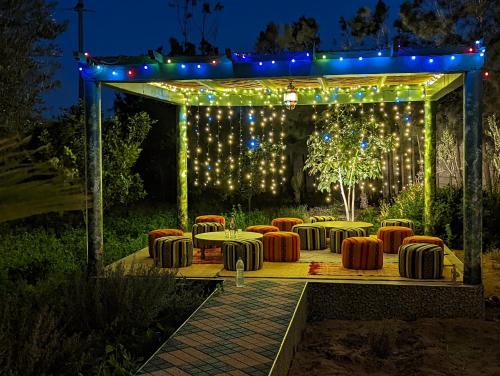 a set of tables and chairs under a gazebo with lights at Dar Beynana in Sidi Bibi