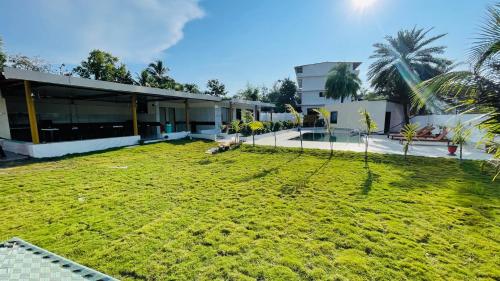a large yard in front of a building at Devka Farm House in Daman