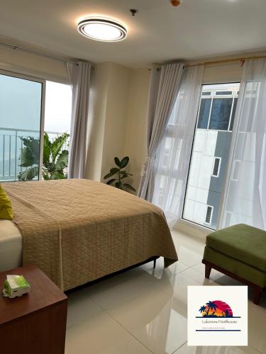 a bedroom with a bed and a large window at Lakeview Penthouse by Timothy in Tagaytay
