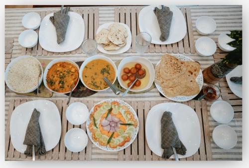 a table with plates of food and bowls of food at Banyan Tree Pool Villa at Surya River Thane in Pālghar