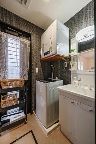 a small kitchen with a sink and a dishwasher at 美ら海かふうテラス in Motobu
