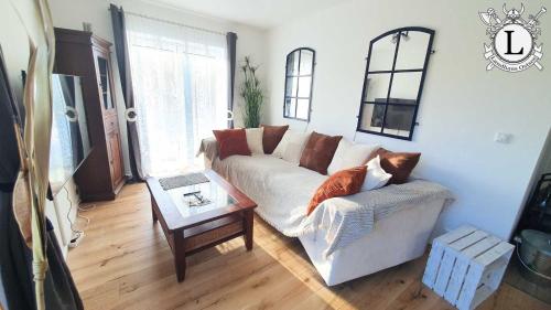 a living room with a white couch and a table at Landhaus Ferien Ostsee in Sterup
