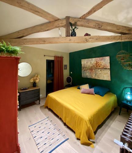 - une chambre avec un lit jaune et un mur vert dans l'établissement Gîte La Maison Mélomane 10 personnes, à Saussens