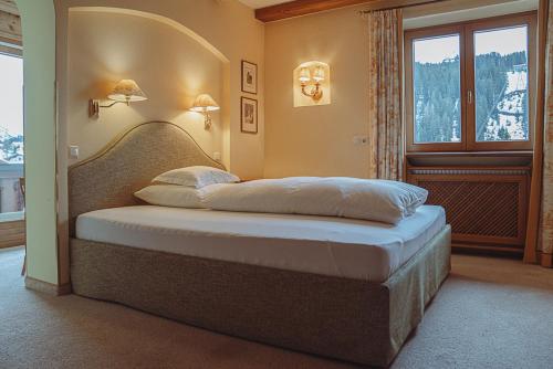 a bedroom with a large bed with a window at Alpenland - Das Feine Kleine in Lech am Arlberg