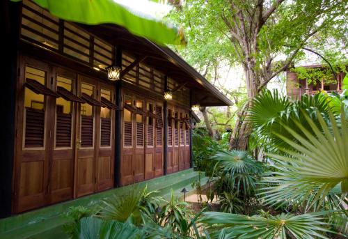 a building with wooden doors in a garden at Villas Sur Mer in Negril