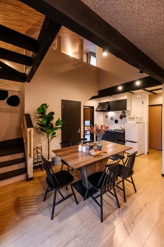 a kitchen and dining room with a wooden table and chairs at 美ら海かふうテラス in Motobu