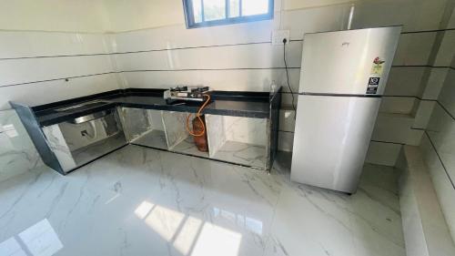 a kitchen with a refrigerator and a counter at Devka Farm House in Daman