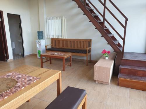 a living room with a couch and a staircase at Freddies Santai Sumurtiga in Sabong