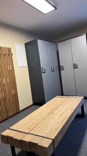 a wooden table in an empty room with lockers at Haus Freunden in Sankt Anton am Arlberg