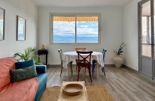 a living room with a table and a couch at Front de mer Beau T3 climatisé Balcon Parking Ajaccio in Ajaccio