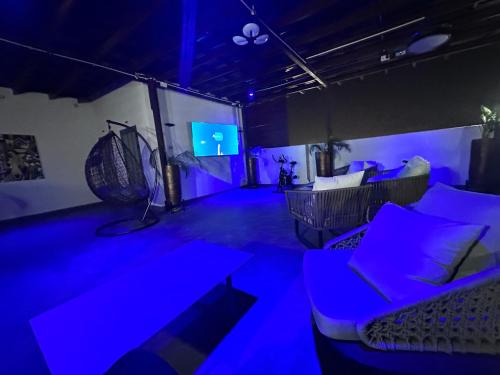a room with blue lights and a couch and a tv at Oyarifa Serenity 340 in Accra