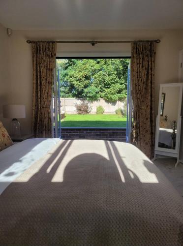 a bedroom with a bed and a large window at Beautiful garden room in Red Lodge