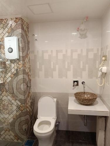 a bathroom with a toilet and a sink at Cameron Greenhill Apartment in Cameron Highlands