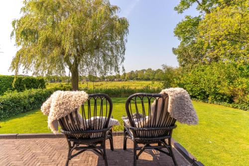 two chairs with pom poms on them sitting in a garden at B&B Wellness 'De Bourgondische Lelie' in Bunschoten