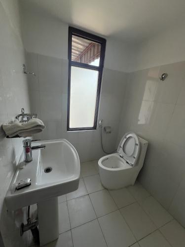 a white bathroom with a sink and a toilet at Sauraha Guest House in Sauraha
