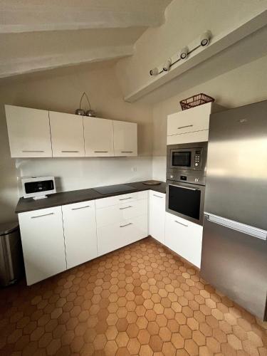 une cuisine blanche avec des armoires et des appareils blancs dans l'établissement Au théâtre, à Colmar
