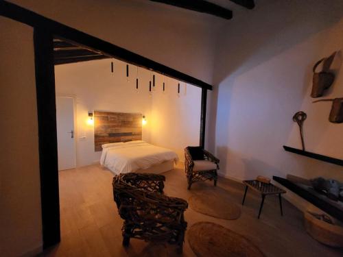 ein Schlafzimmer mit einem Bett und einem Stuhl in einem Zimmer in der Unterkunft La Casa Rosa de Finca Doña Carmen in Santomera