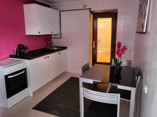 eine Küche mit rosa Wänden, einem Tisch und einem Waschbecken in der Unterkunft La Casa Rosa de Finca Doña Carmen in Santomera