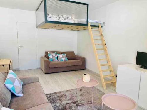 - un salon avec un canapé et une échelle sur le mur dans l'établissement Appartement familial aux pieds des pistes, à Saint-Étienne-en-Dévoluy