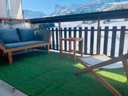 d'une terrasse avec un canapé et une table sur un balcon. dans l'établissement Appartement familial aux pieds des pistes, à Saint-Étienne-en-Dévoluy