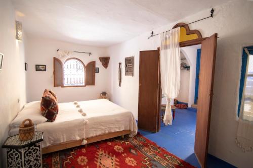 a bedroom with a bed and an open door at Dar YAMINA RASELMA in Chefchaouene