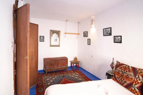 a bedroom with a bed and a table in a room at Dar YAMINA RASELMA in Chefchaouene