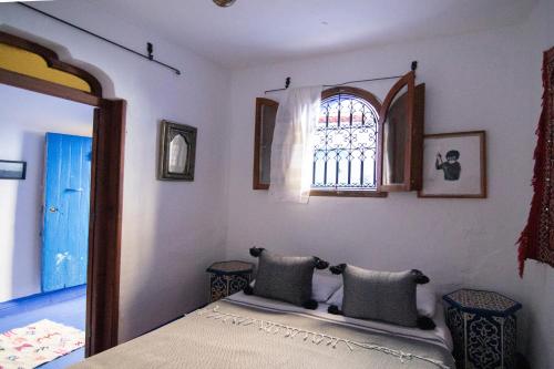 a bedroom with a bed and a window at Dar YAMINA RASELMA in Chefchaouene