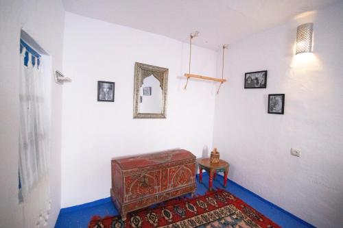 a room with a small table and a mirror on the wall at Dar YAMINA RASELMA in Chefchaouene