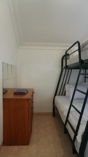 a room with two bunk beds and a wooden desk at Villa Dalia Puncak NA4-11 in Cianjur