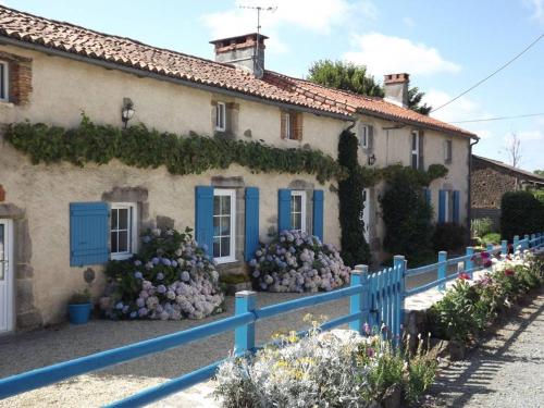 ein Haus mit blauen Fensterläden und einem blauen Zaun in der Unterkunft La Gondromière 79140 CERIZAY in Cerizay