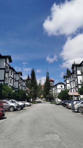 a parking lot with cars parked in front of buildings at Cameron Greenhill Apartment in Cameron Highlands