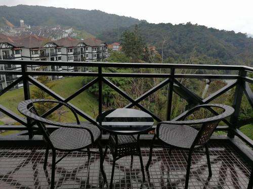 a table and chairs sitting on top of a balcony at Cameron Greenhill Apartment in Cameron Highlands