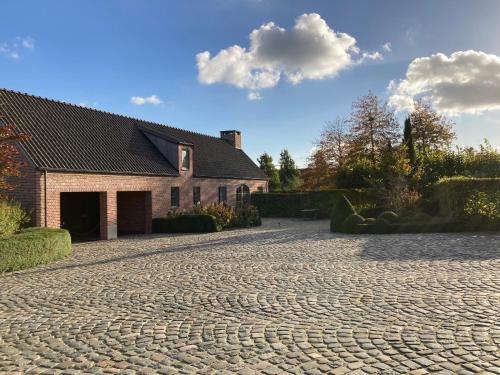 a cobblestone driveway in front of a house at Hoeve Sterrewijk in Aalter