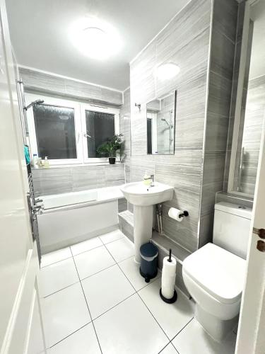 a white bathroom with a sink and a toilet at London Rooms King's Cross in London